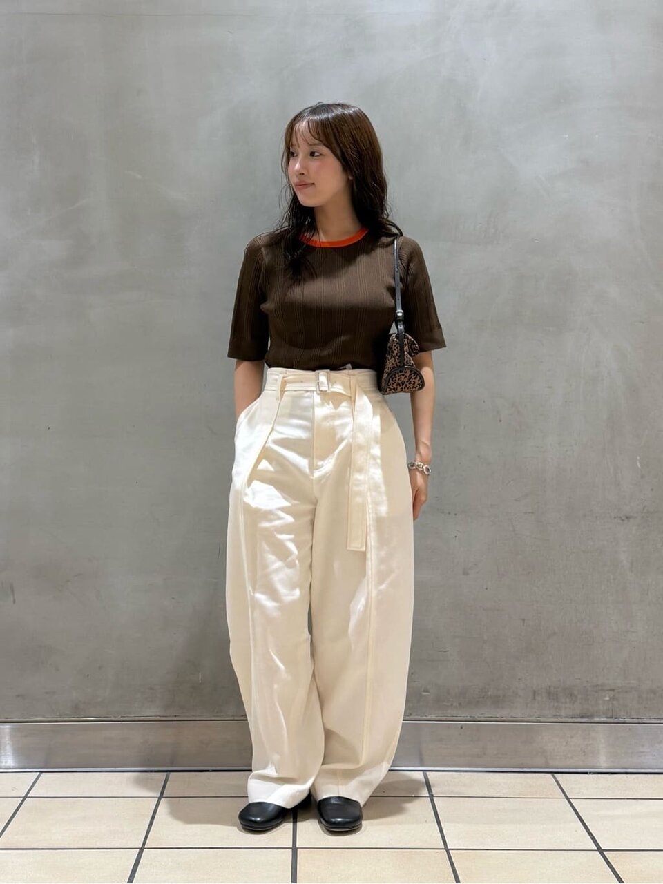 ハーフスリーブニットと白いパンツを着た女性