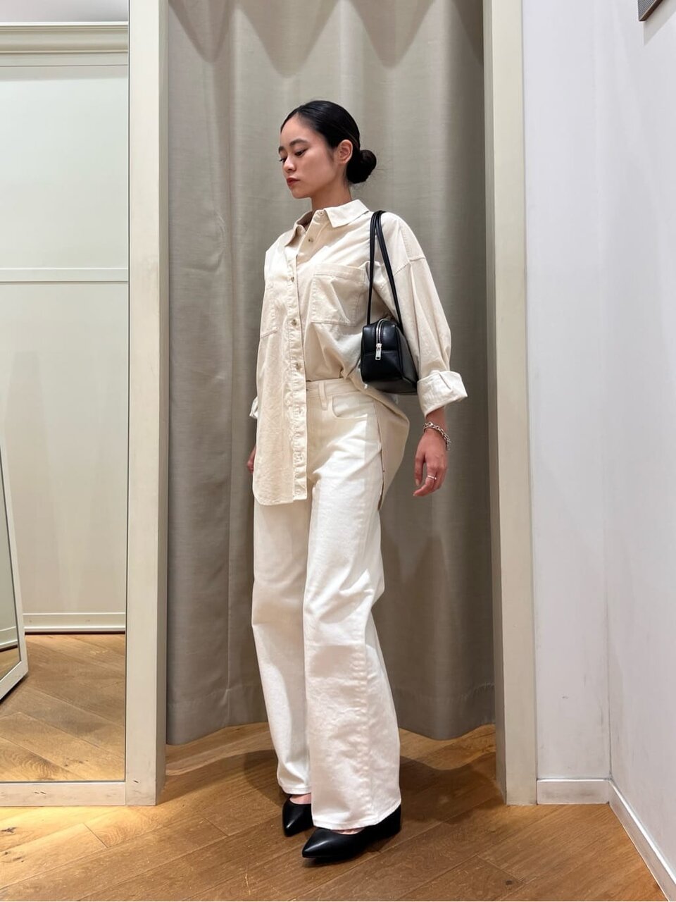 コーデュロイシャツと白いパンツを着た女性