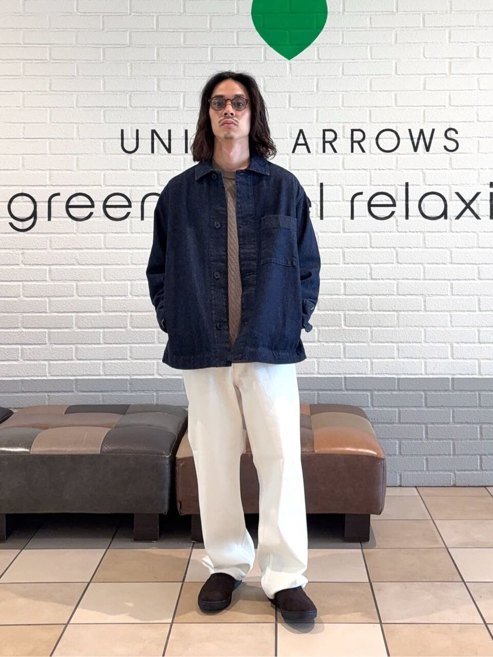 カバーオールと白パンツを着た男性