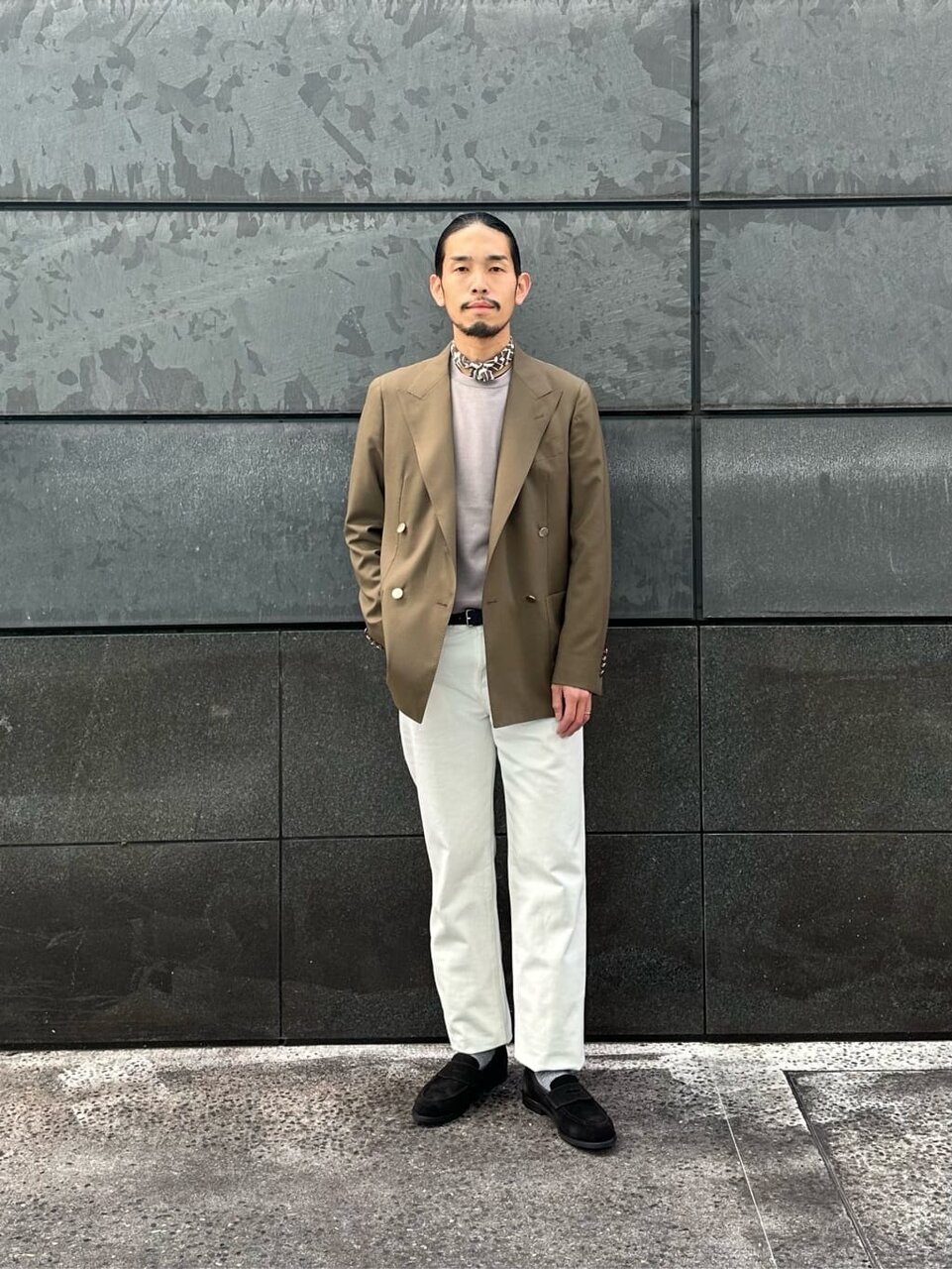 テーラードジャケットと白パンツを着た男性