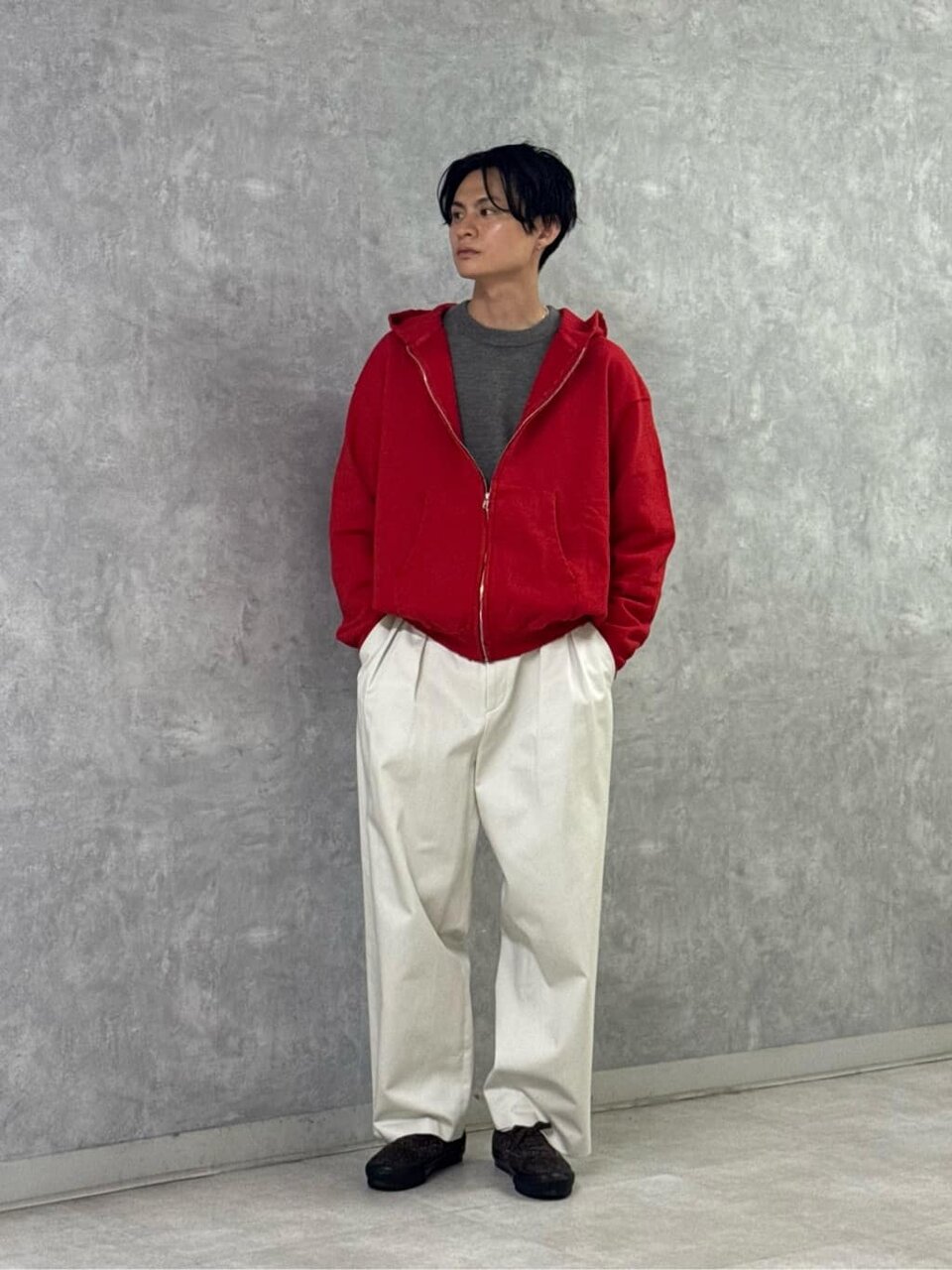 赤いフーディーと白パンツを着た男性