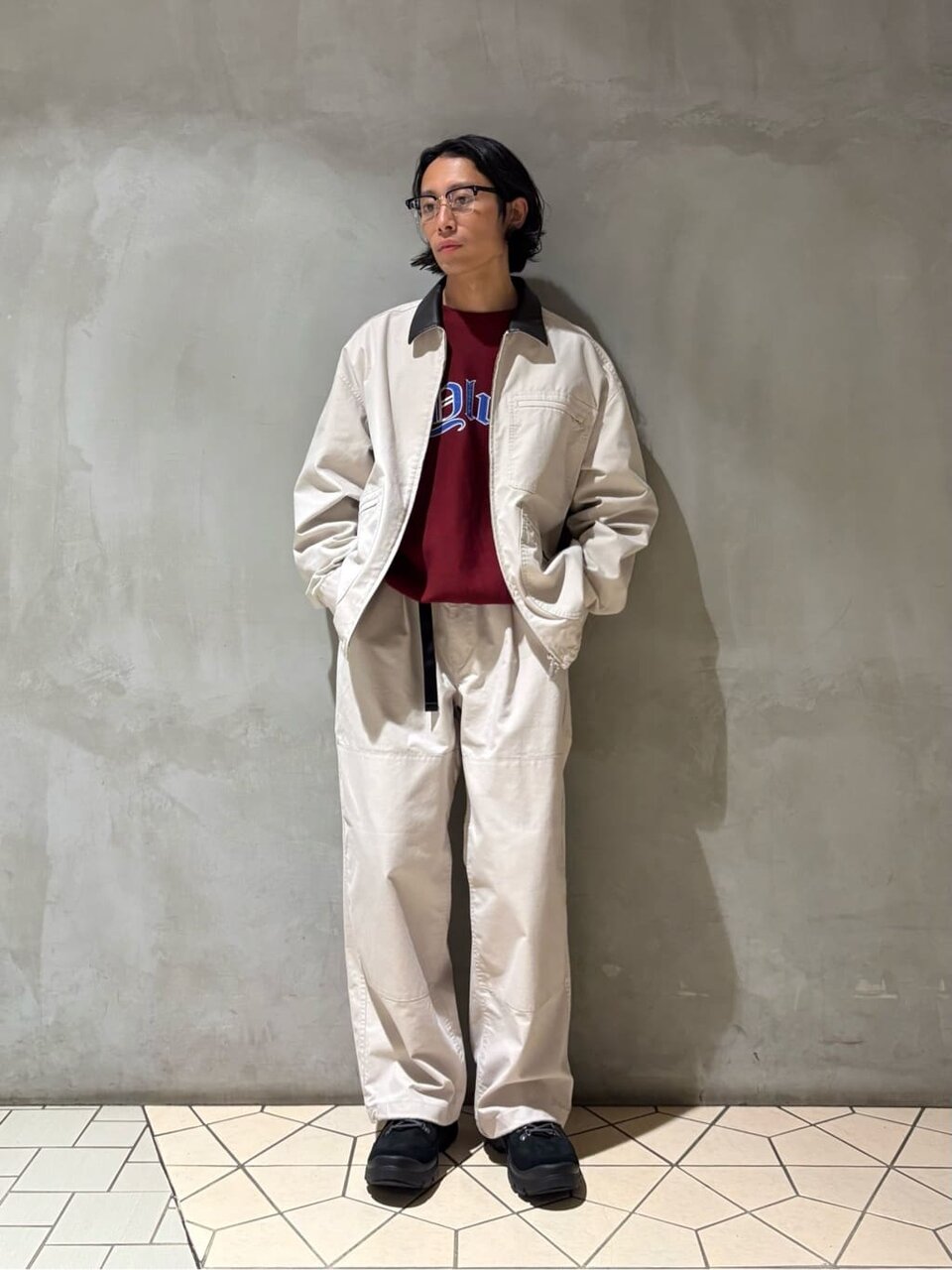 ブルゾンと白パンツを着た男性