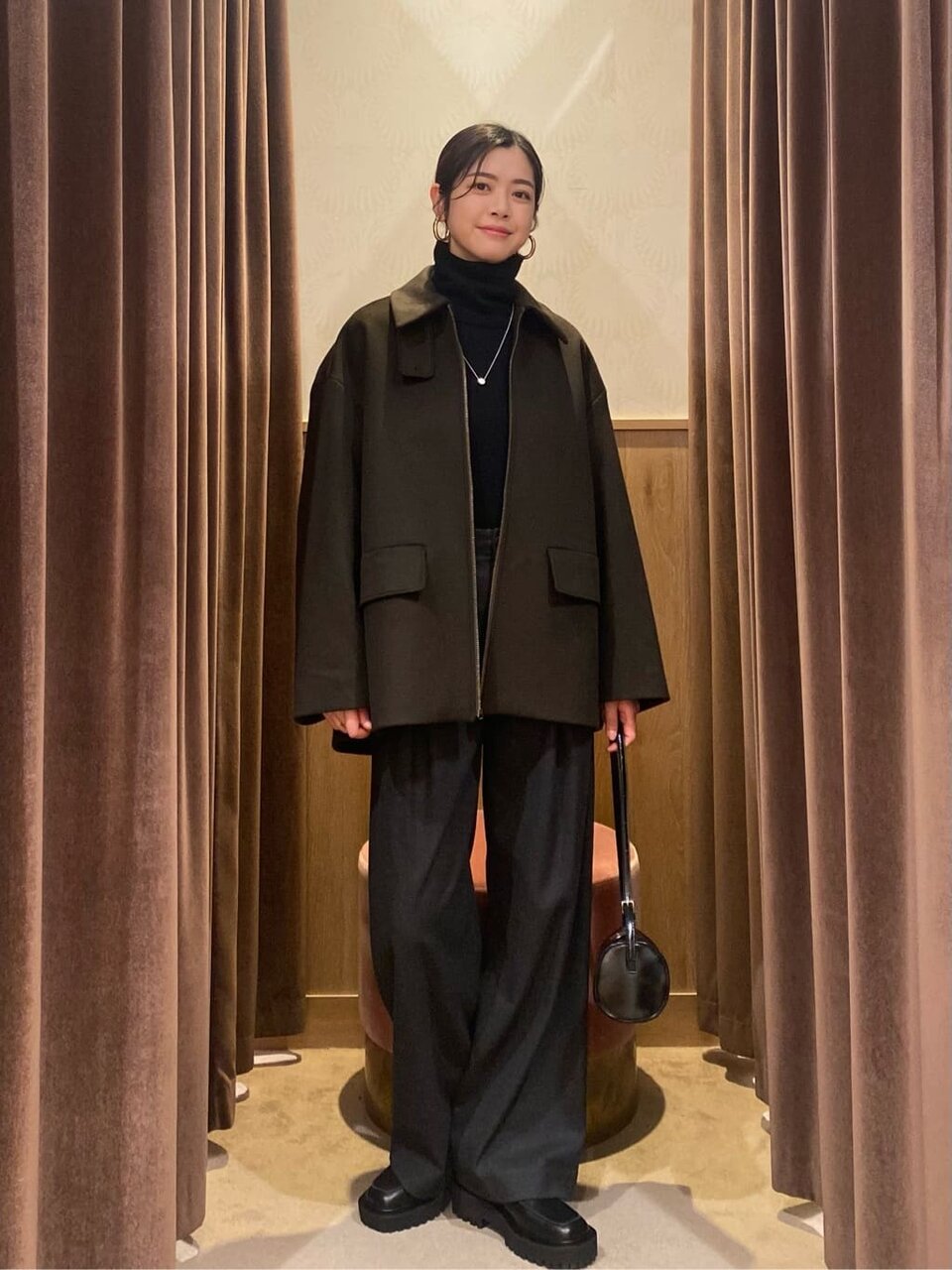 ダークグリーンのジップコートを着た女性