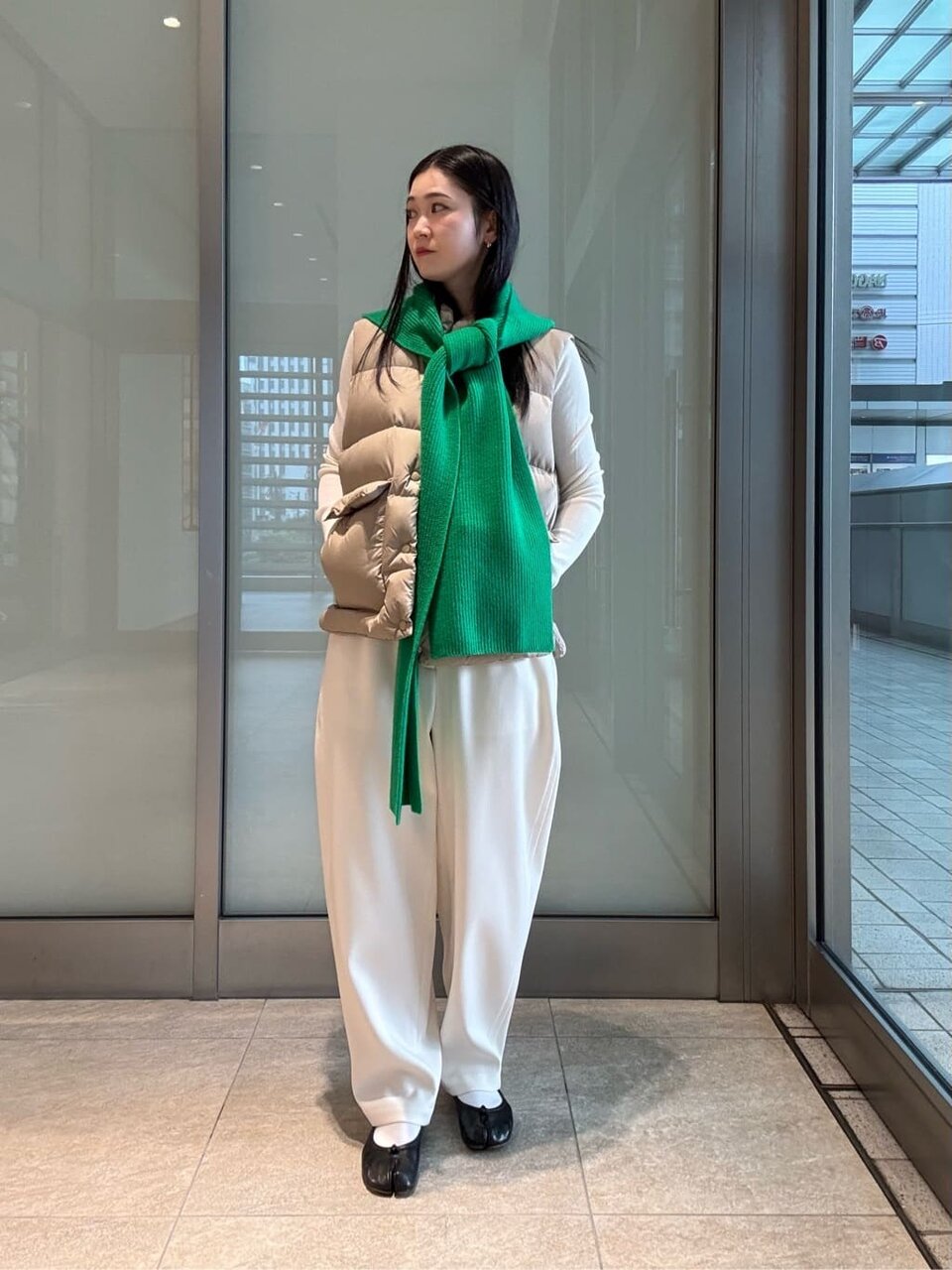 ケリーグリーンのフードマフラーをした女性