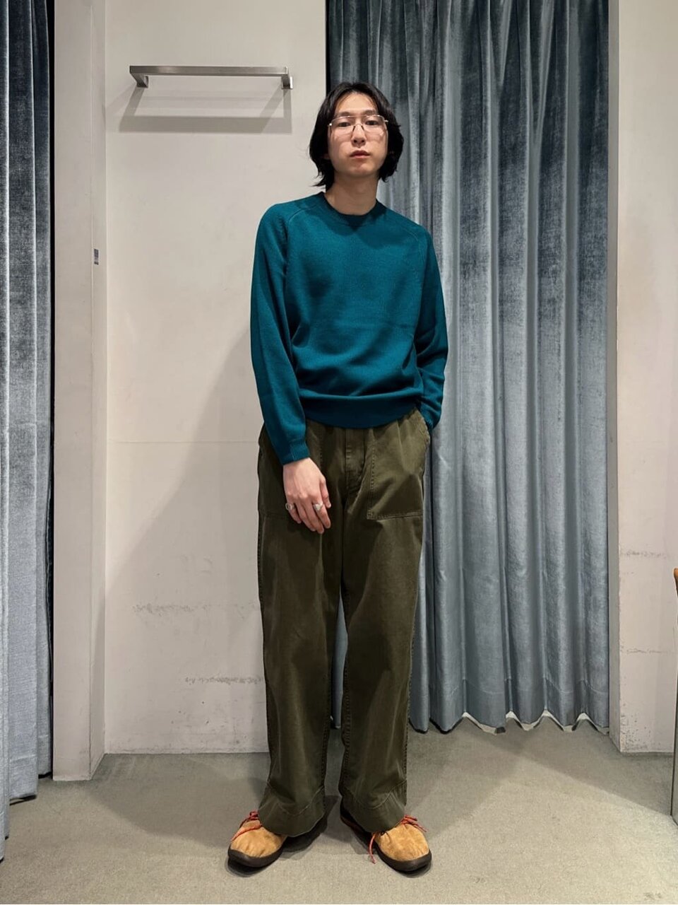 オリーブグリーンのワイドベイカーパンツを着た男性