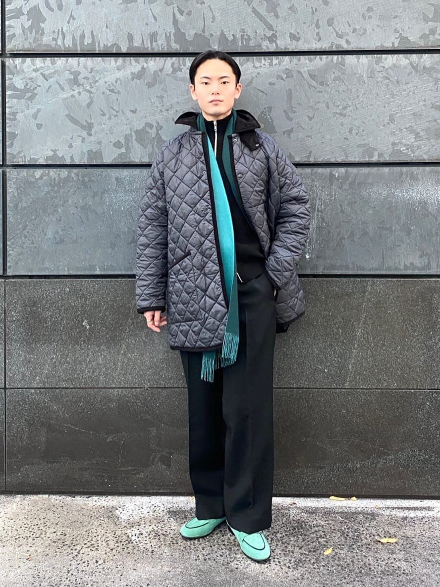 ダークグリーンのリバーシブルマフラーをした男性