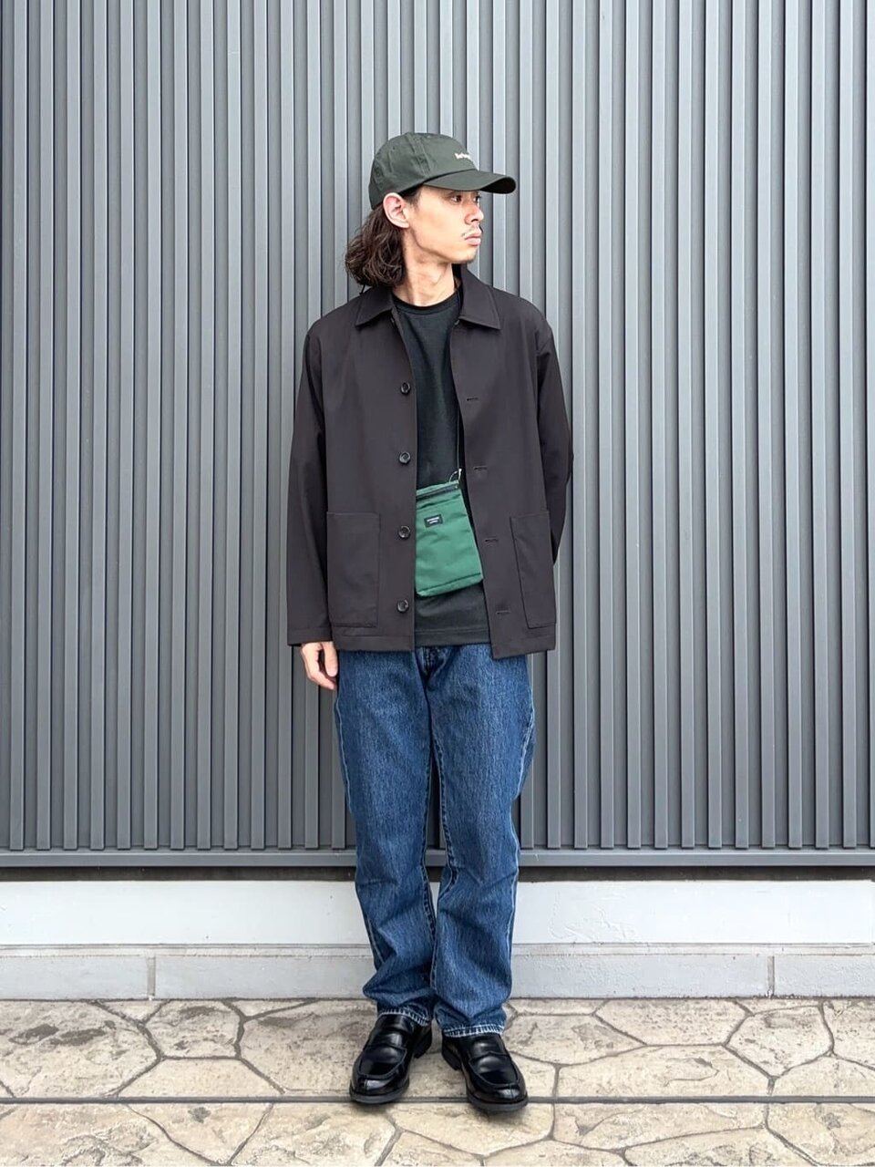 ダークグリーンのショルダーバッグ を持った男性