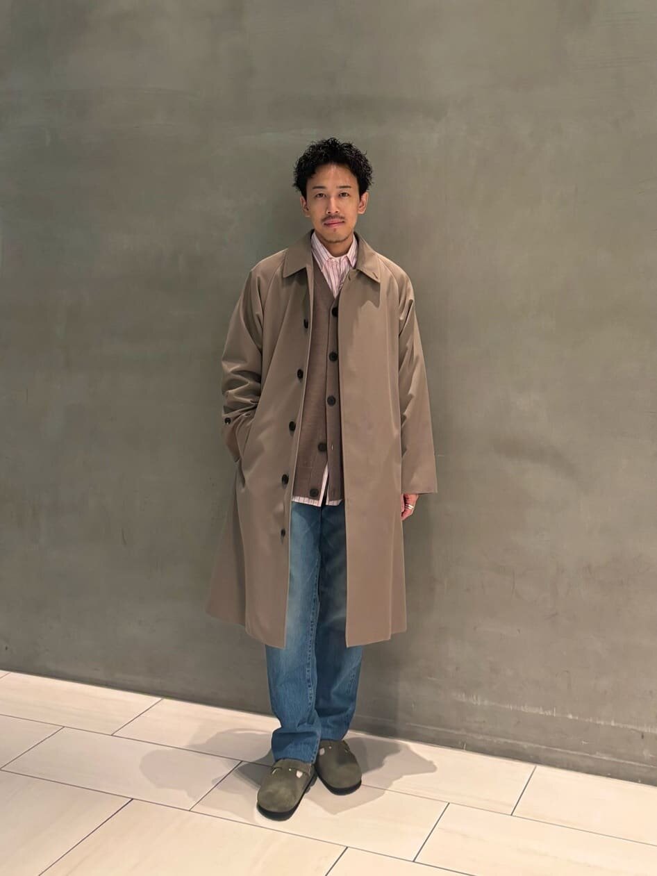 ステンカラーコートとデニムを着た男性