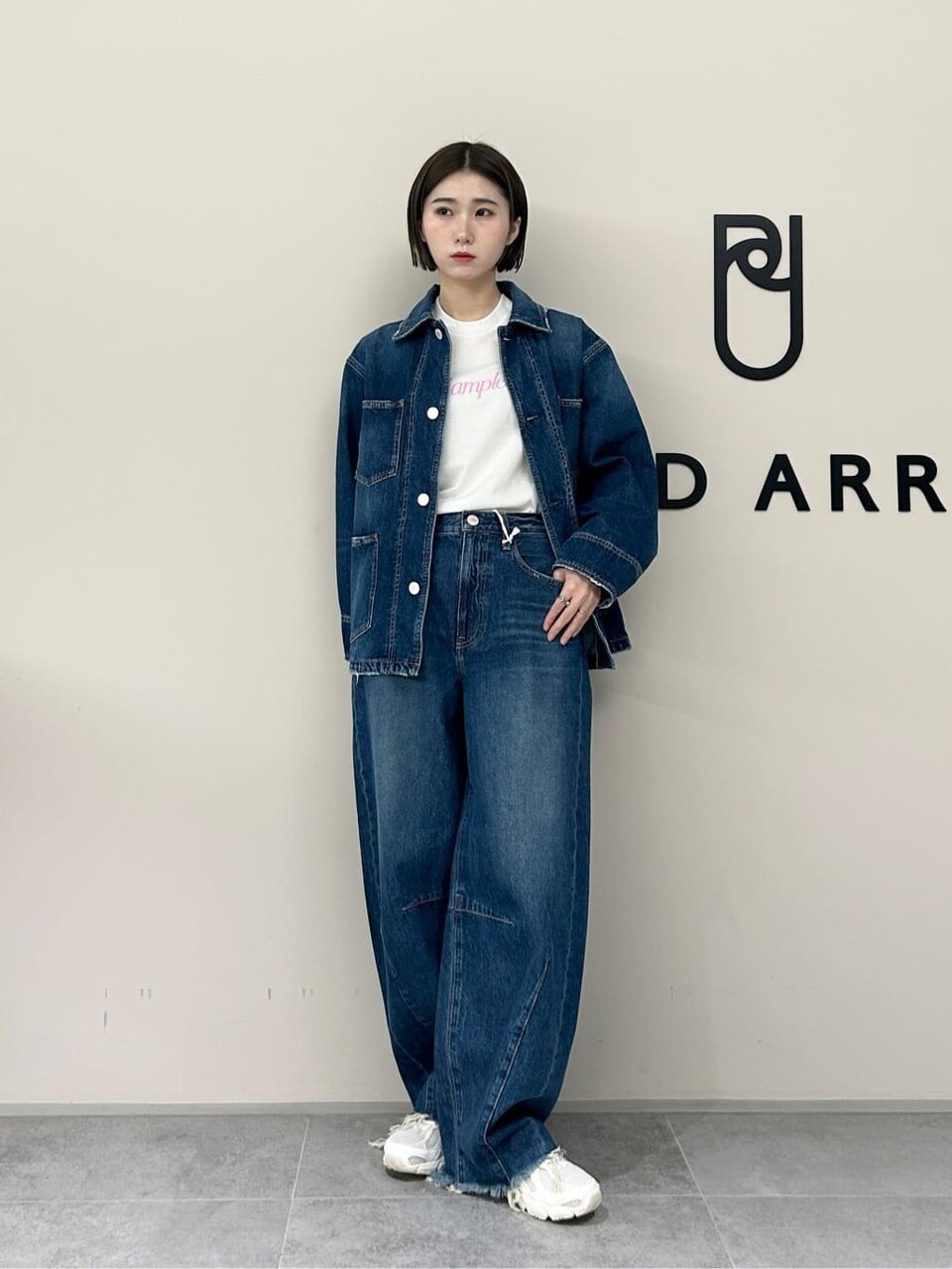 デニムジャケットとスニーカーの女性