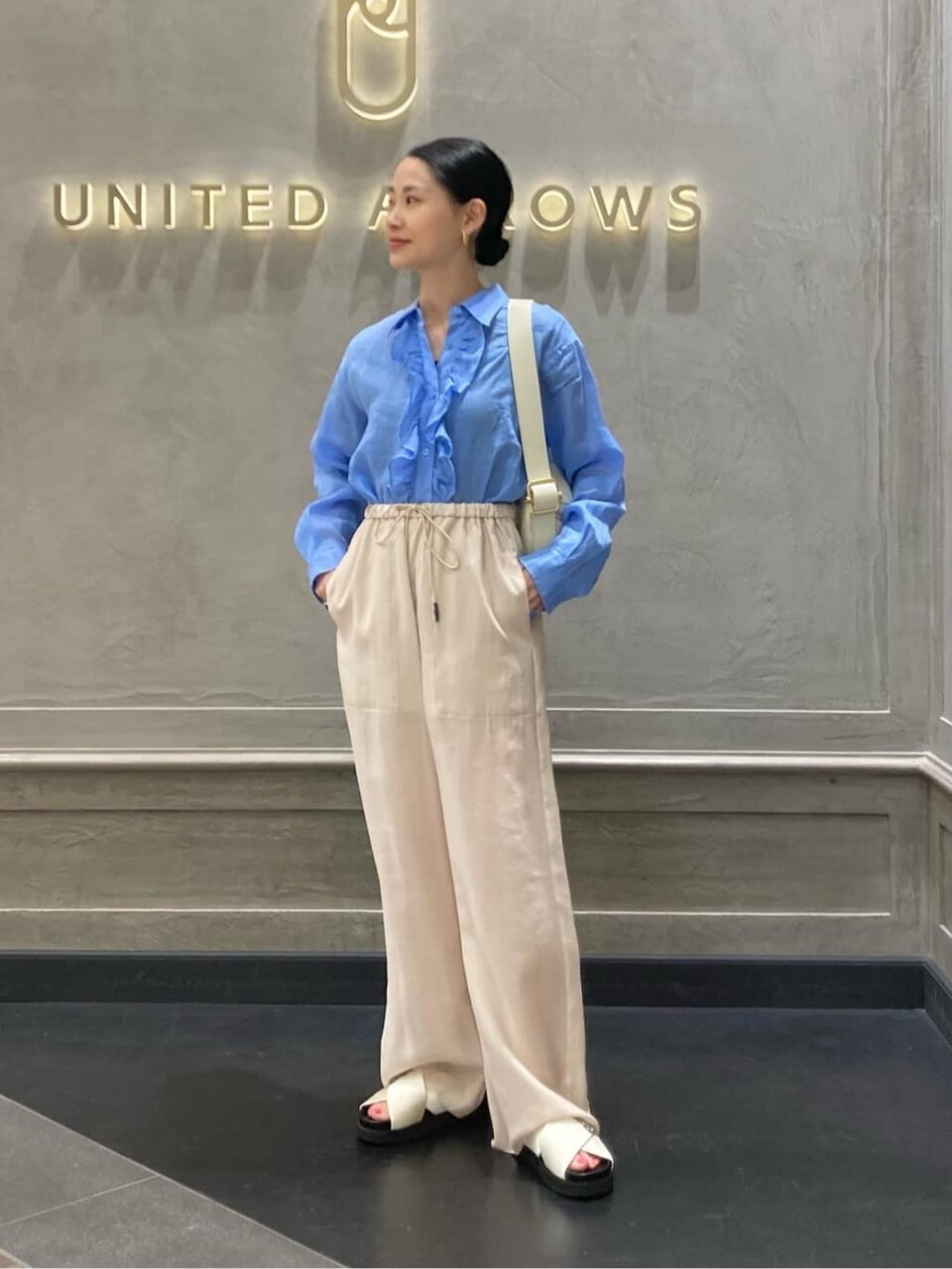 イージーパンツとクロスサンダルの女性