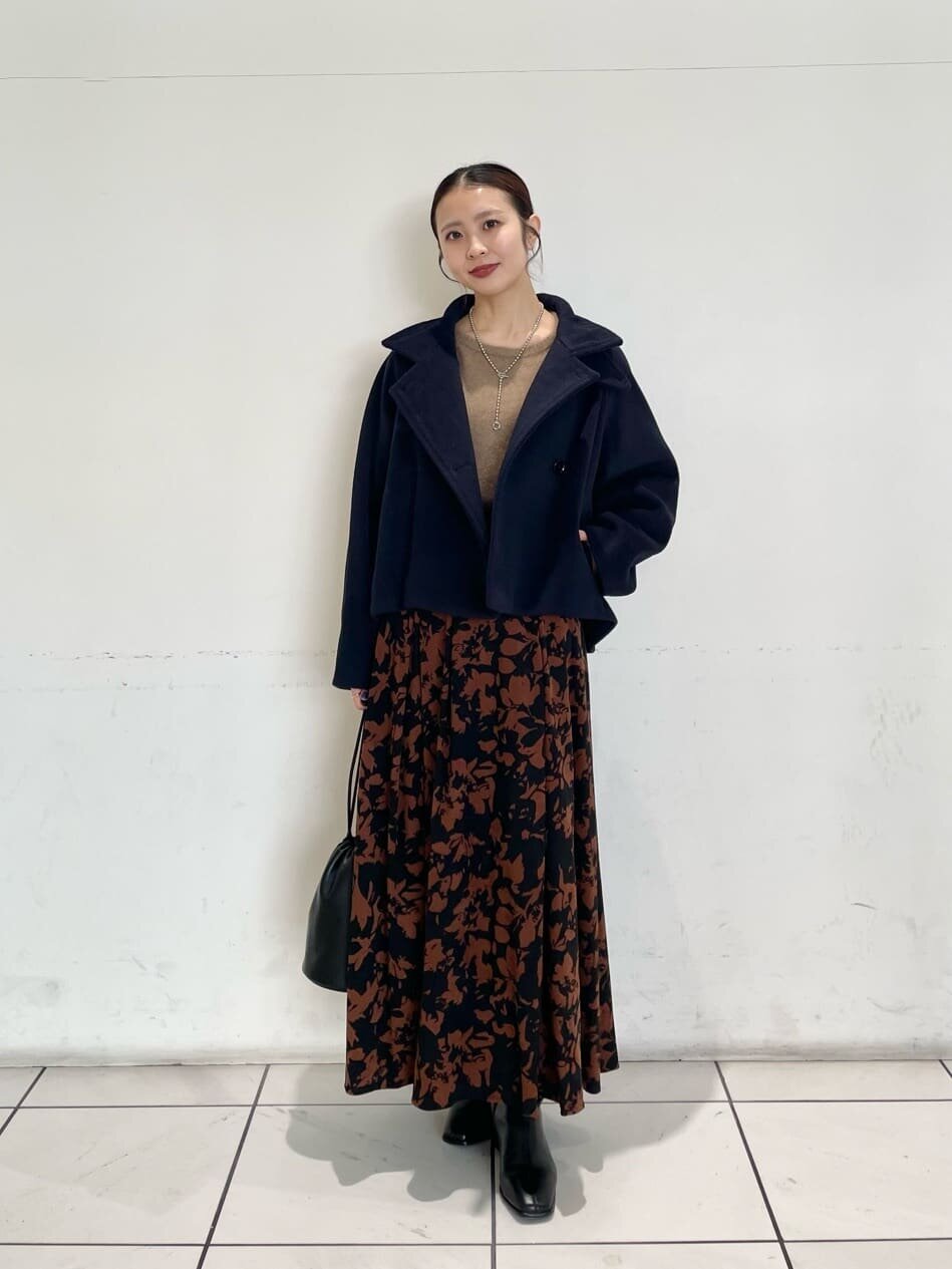 青いロングスカートと黒いトップスを着た女性