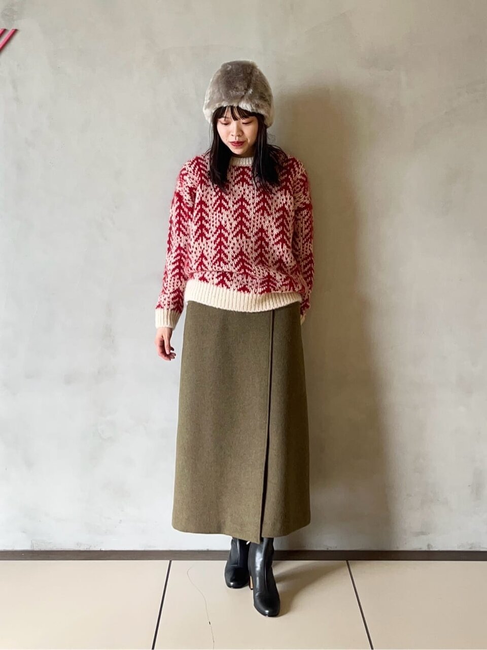 青いロングスカートと黒いトップスを着た女性