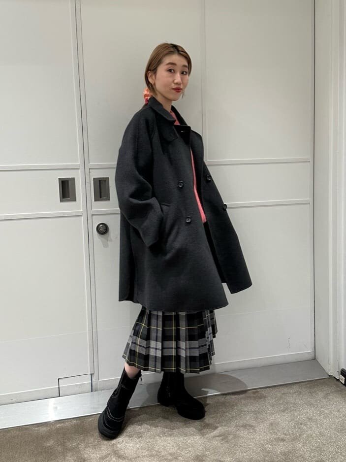 青いロングスカートと黒いトップスを着た女性