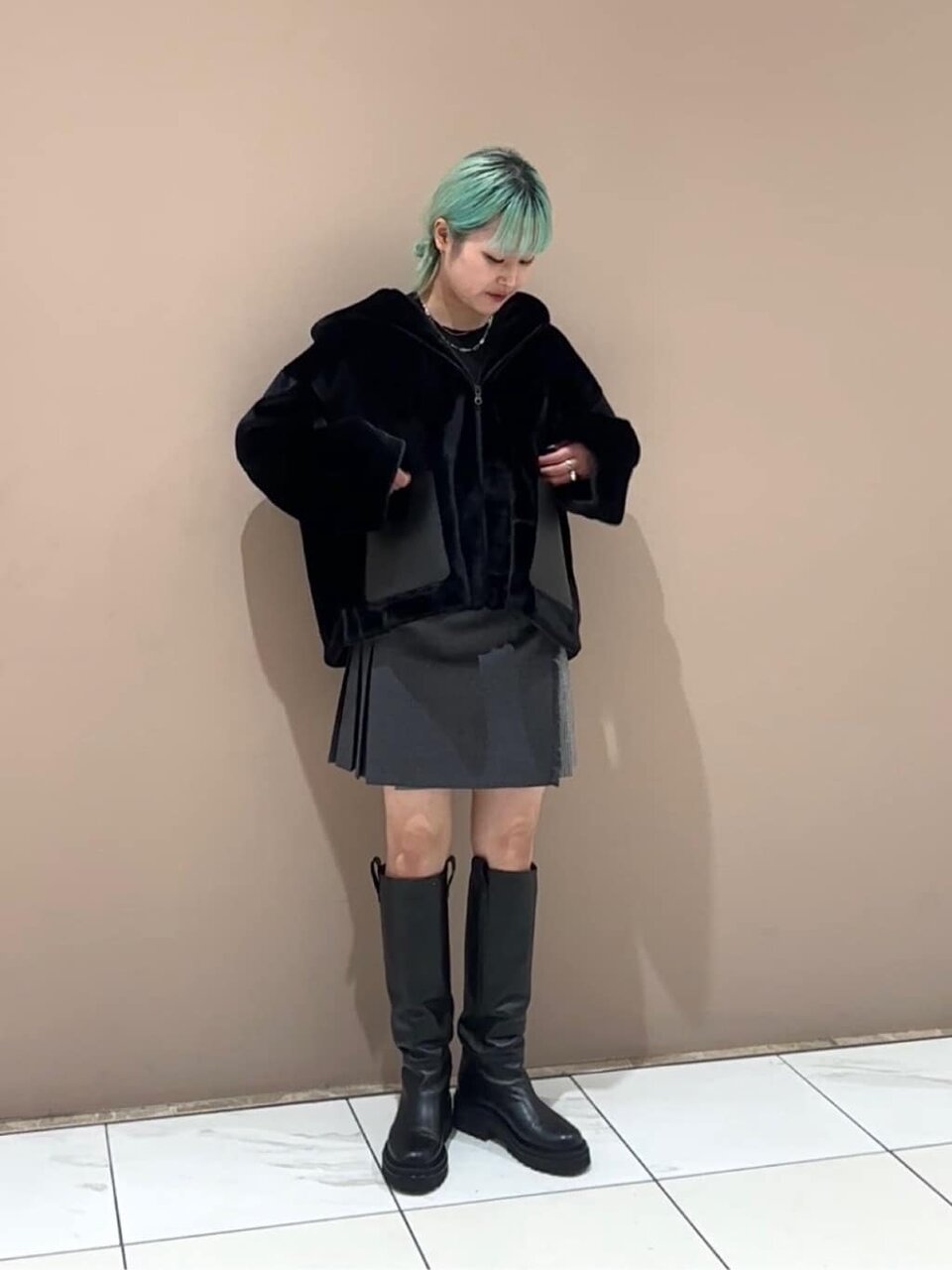 青いロングスカートと黒いトップスを着た女性