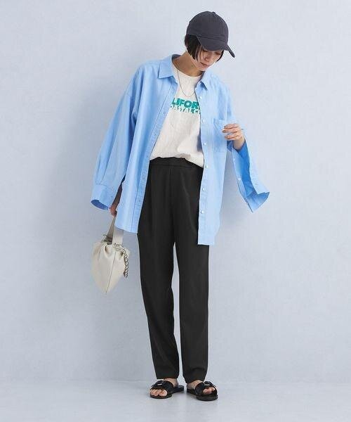 オーバーシャツとテーパードパンツを着用した女性