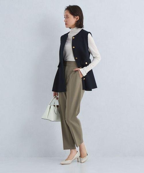 ジレとテーパードパンツを着用した女性