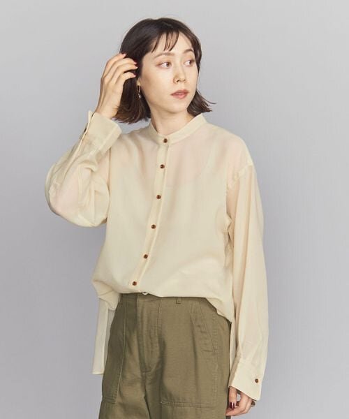 ベージュのシアーシャツを着た女性