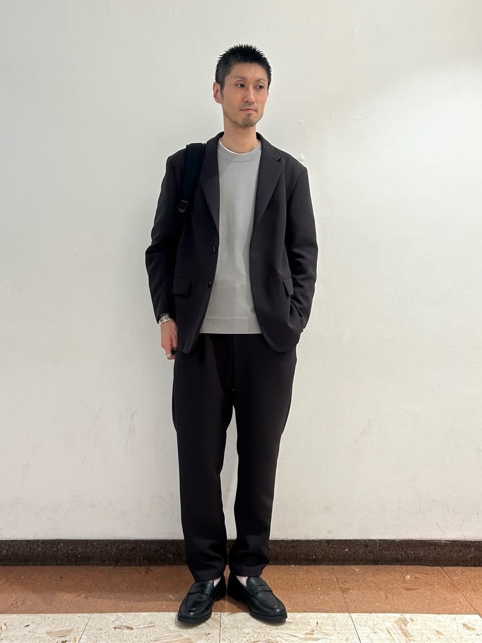 ライトグレーのニットとダークブラウンのセットアップの春のオフィスカジュアルコーデ