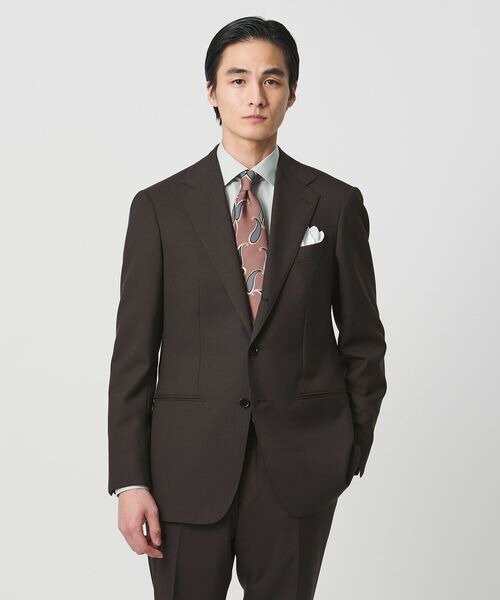 ブラウンのスーツにペイズリー柄のネクタイの男性