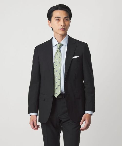 黒のスーツに小紋柄のネクタイの男性