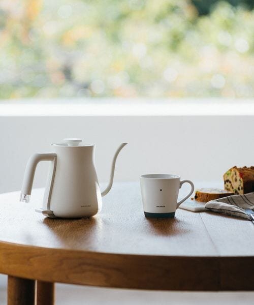 机の上に白いポット、マグカップ、お菓子がある　ティータイム　
