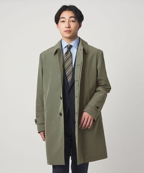 スーツにスプリングコートを着た男性