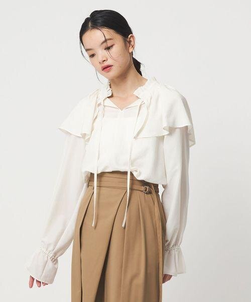 ブラウスをタックインした女性