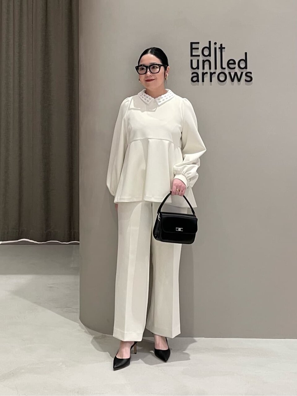 ブラウスとパンツのセットアップを着た女性