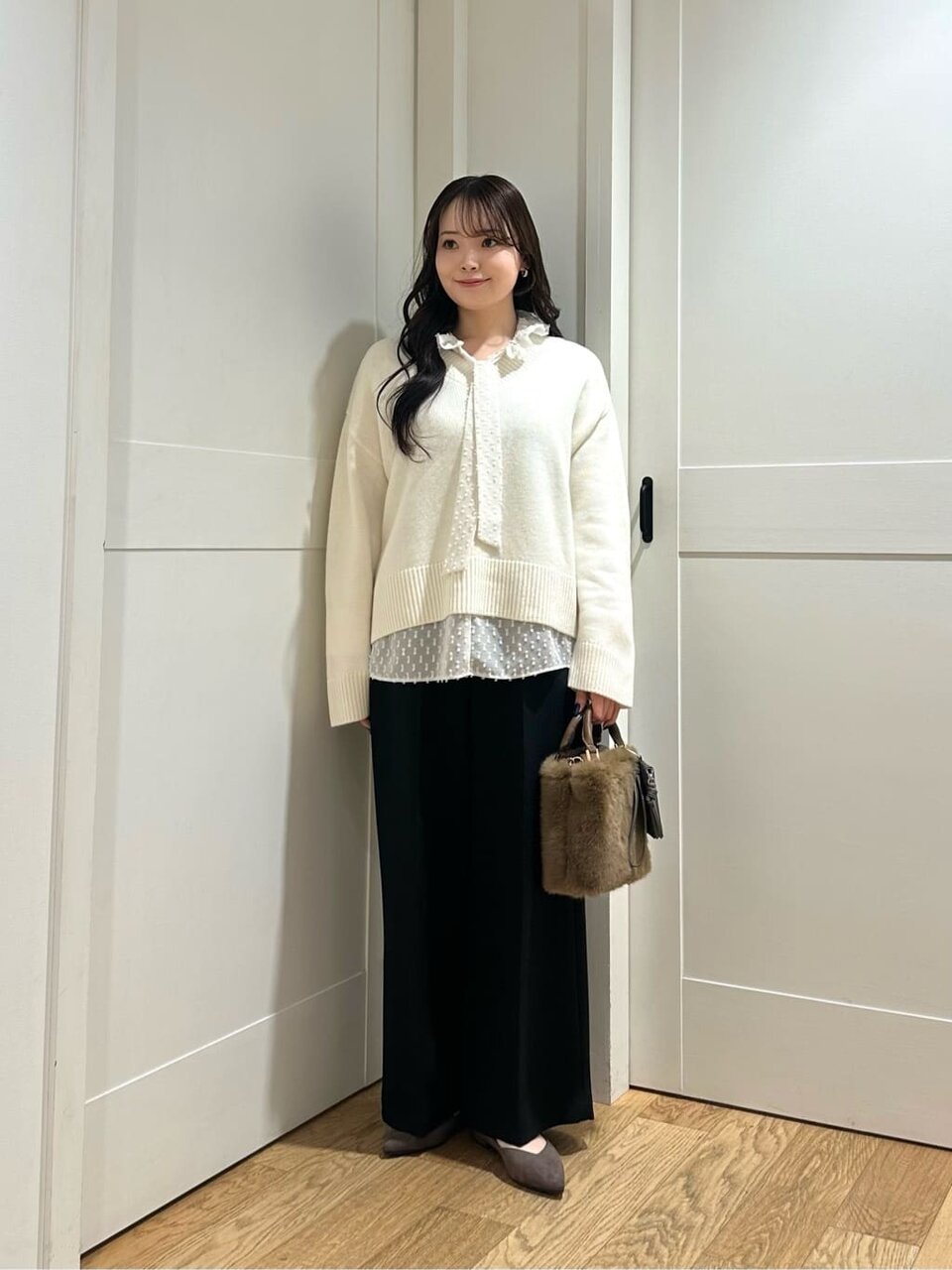 ニットとブラウスをレイヤードした女性