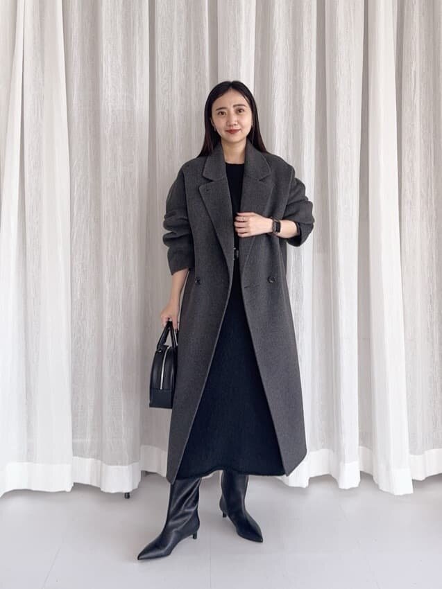 チェスターコートとワンピースを着た女性
