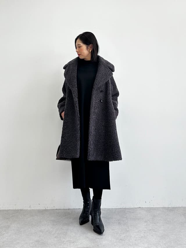 ボアコートとニットワンピースを着た女性