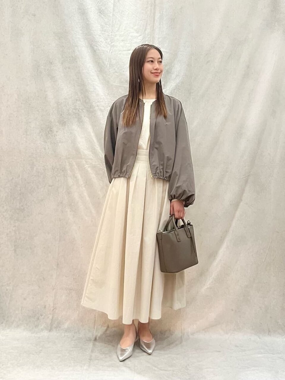 ブルゾンとフレアスカートを着た女性