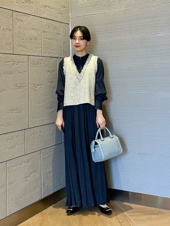 シャツワンピースとベストを着た女性