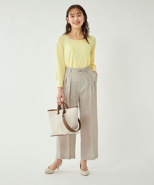 ベージュのワイドパンツをはいた女性