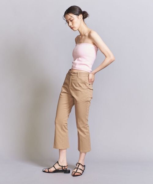 ベージュのフレアパンツをはいた女性