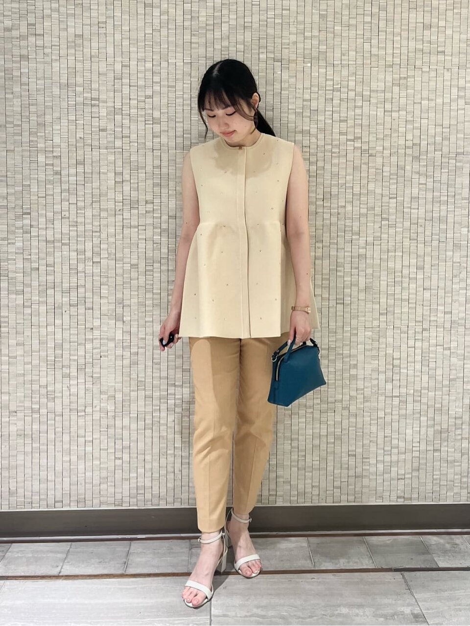ノースリーブニットとベージュパンツのコーデ