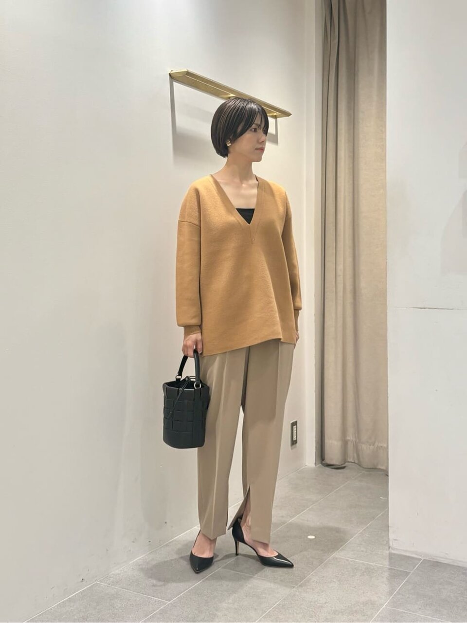 Vネックニットとベージュパンツのコーデ