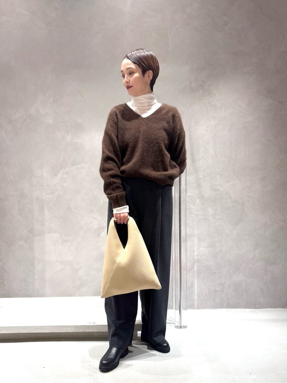 Vネックニットとワイドパンツを着た女性