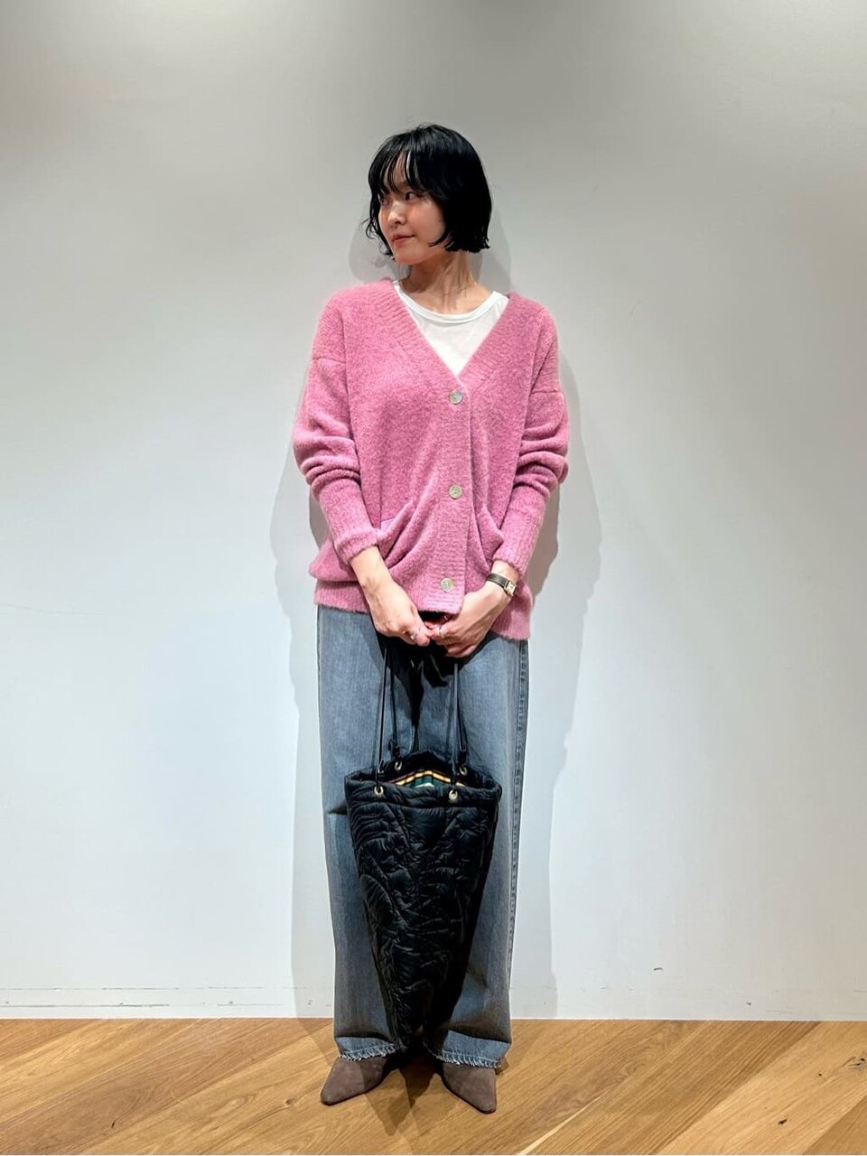 ピンクのカーディガンとデニムを着た女性