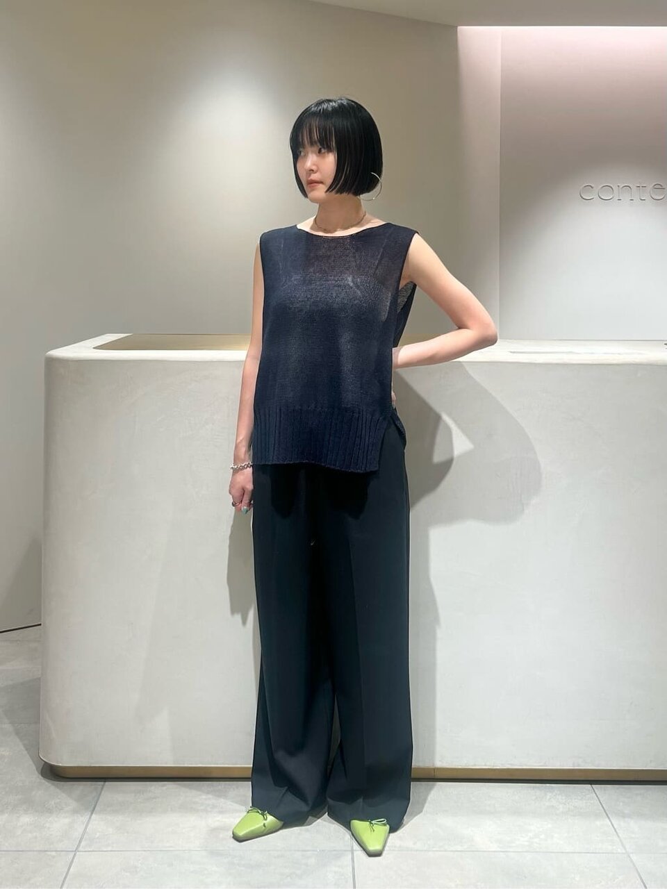 シアーニットとワイドパンツを着た女性