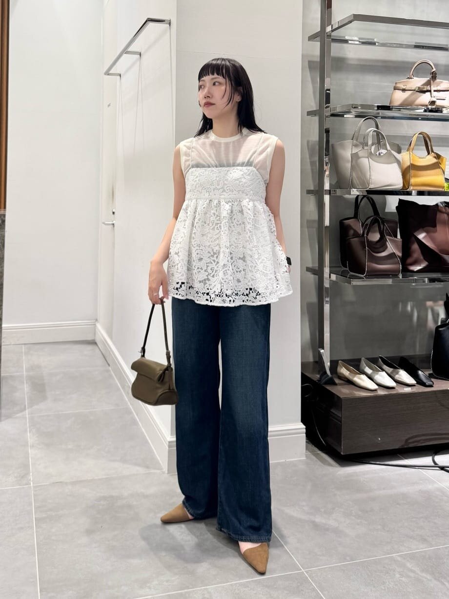 ノースリーブニットとデニムを着た女性