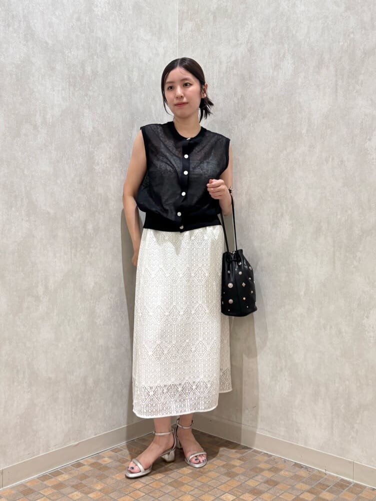 ニットジレとレーススカートを着た女性