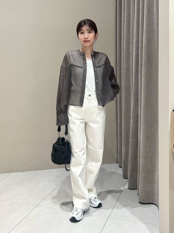 シアーシャツと白いパンツを着た女性