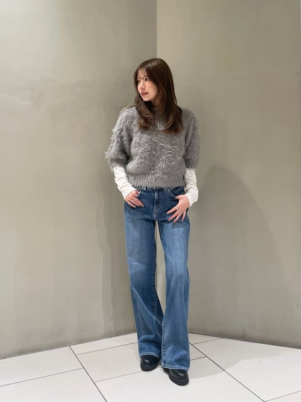 フェザーニットとデニムを着た女性