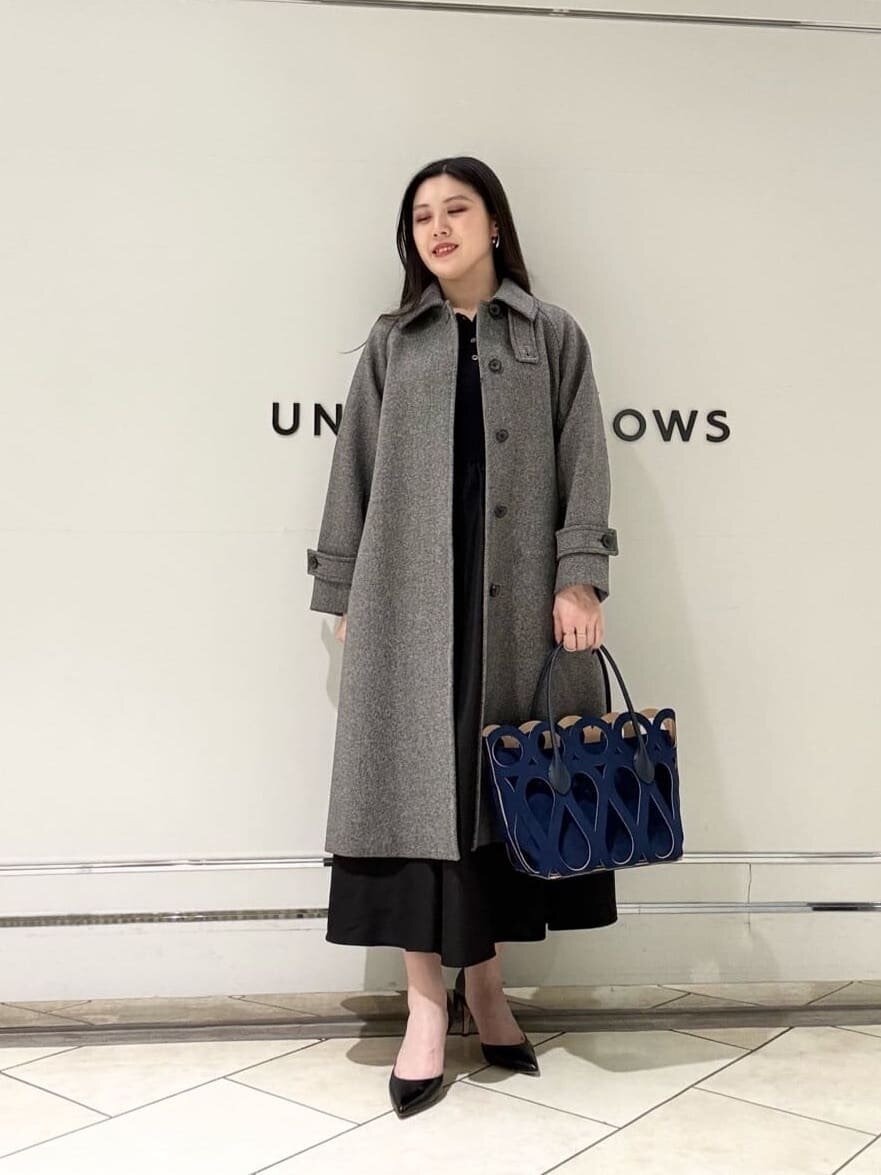 ロングコートとワンピースを着た女性