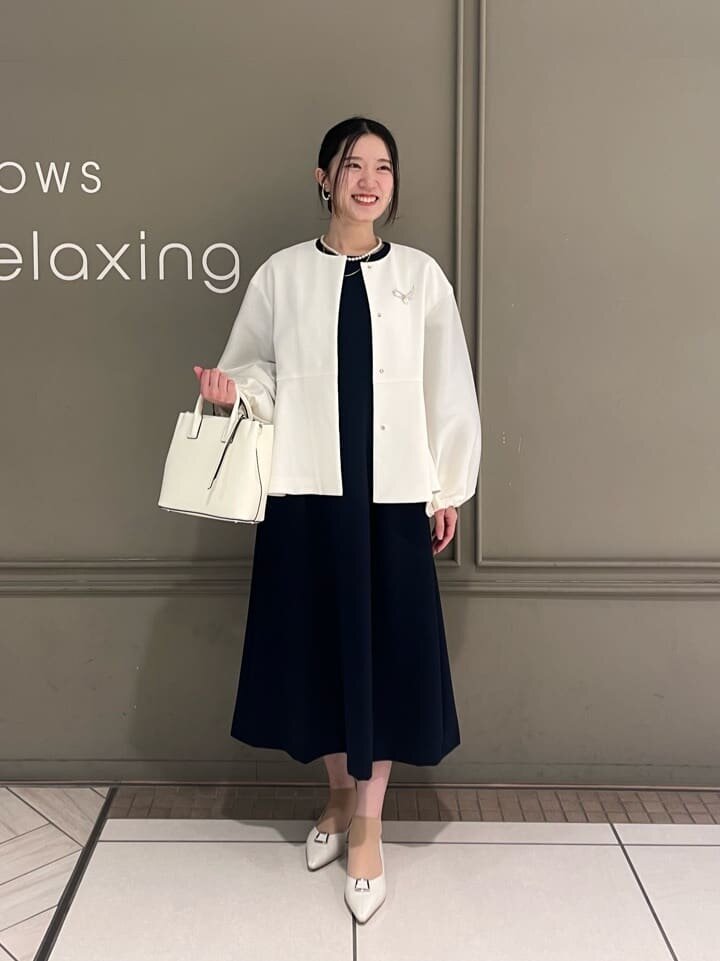 ノーカラージャケットとワンピースを着た女性