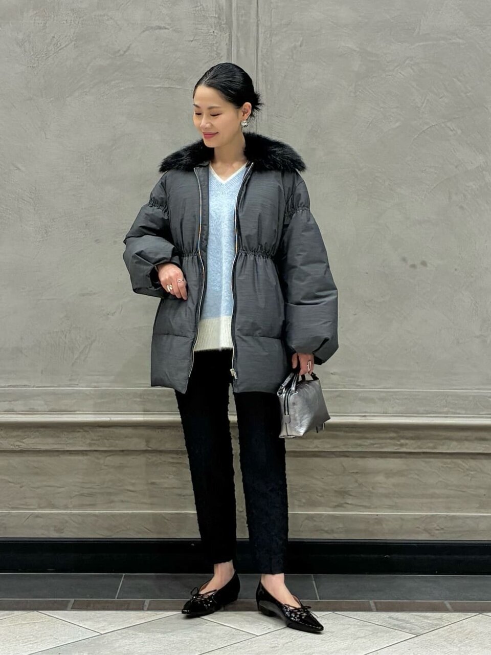 ダウンジャケットとテーパードパンツを着た女性