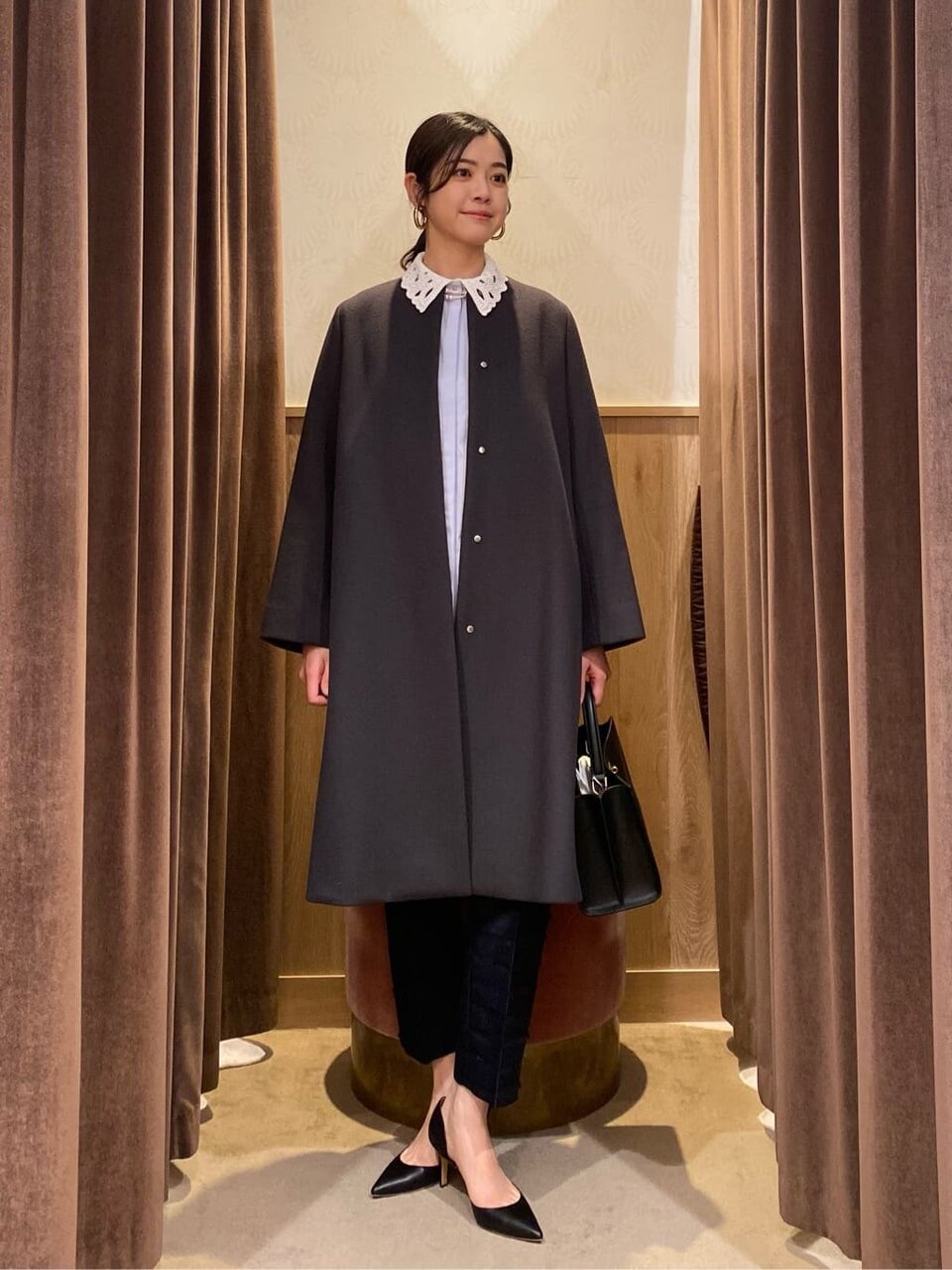 ノーカラコートとテーパードパンツを着た女性