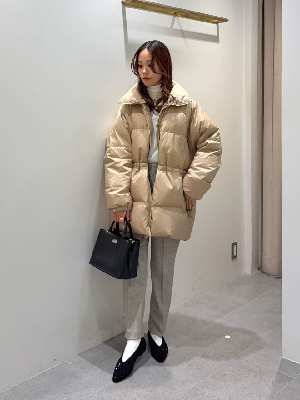 ダウンジャケットとテーパードパンツを着た女性