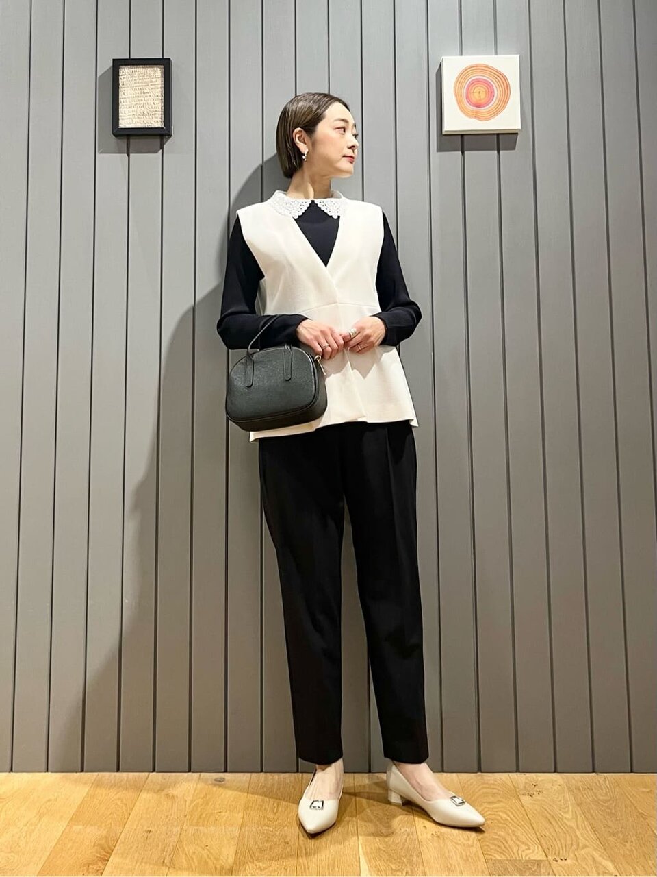 ペプラムジレとテーパードパンツを着た女性